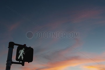 Walk signal with sunset in the background