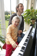 Hamburg  Deutschland  Vater und Tochter spielen Klavier