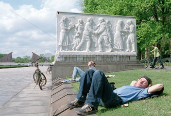 Besucher liegen im Park des sowetischen Ehrenmals in Treptow