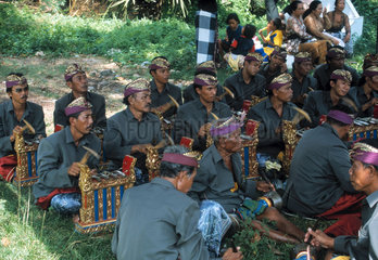 Traditionelles balinesisches Gamelanorchester spielt waehrend einer Beerdigung