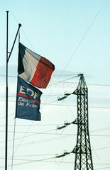 Trikolore und Fahne mit EdF Logo vor Strommast