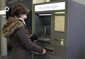 Lueneburg  Deutschland  Frau hebt Geld an einem Automaten der Dresdner Bank ab