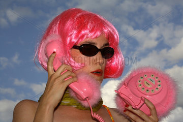 Berlin  Frau telefoniert mit rosafarbenem Telefon
