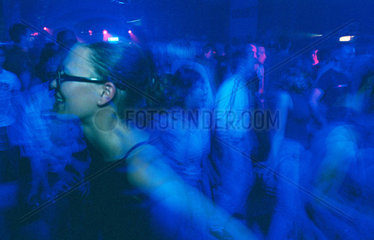 Tanzende Frau in blauem Licht in einem Berliner Club