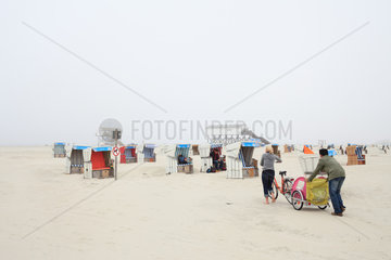 Sankt Peter-Ording  Deutschland  Strandkoerbe und Menschen bei Nebel am Strand