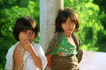 Zwei Kinder stehen wartend an einer Laterne in Lombok