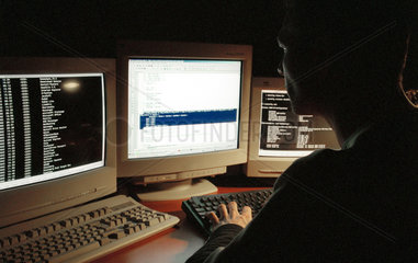 Ein junger Mann sitzt vor Computermonitoren