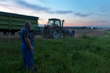 Penzlin  Deutschland  Landwirte bei der Ernte am spaeten Abend