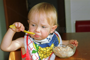 Ein Kleinkind isst sein Muesli