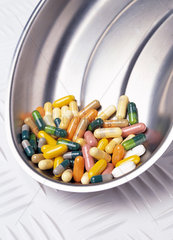 Verschiedenfarbige Tabletten liegen in einer Nierenschale aus Edelstahl
