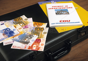 Aktenkoffer mit Parteiwerbung der CDU und Eurogeldscheinen