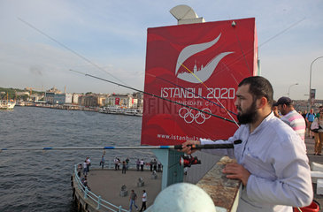 Istanbul  Tuerkei  Angler vor Plakat fuer die Olympischen Spiele auf der Galatabruecke