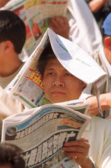 Zuschauer beim Zeitunglesen auf der Rennbahn  Hongkong