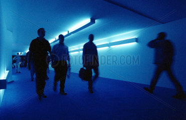 Besucher auf der IFA in einem blau beleuchteten Gang