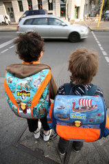 Berlin  Deutschland  Kinder auf dem Schulweg stehen an einer befahrenen Strasse