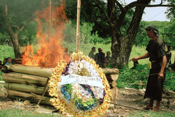 Ein Mann kontrolliert die Verbrennung eines Toten nach hinduistischem Ritual