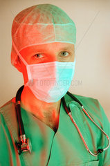 Arzt mit OP-Kleidung  Haube  Mundschutz und einem Stethoskop