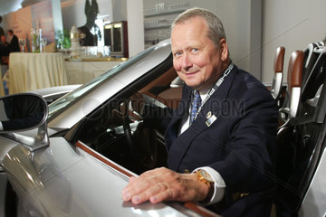Doktor Wolfgang Porsche im Portrait am Auto