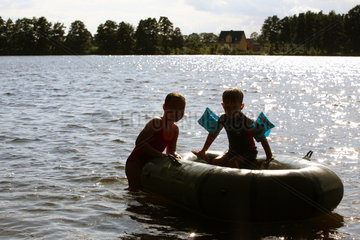 Wusterhausen  Deutschland  Silhouette von Kindern mit einem Schlauchboot im See