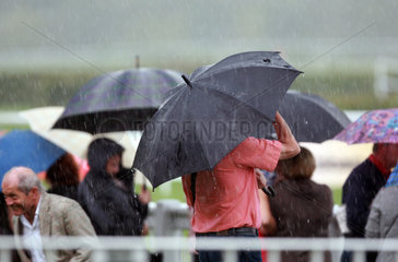 Iffezheim  Deutschland  Menschen stehen bei Schlechtwetter unter ihren Regenschirmen