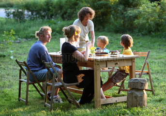 Schependorf  Deutschland  Familie und Freundin essen im Garten