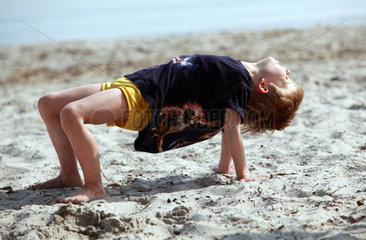 Klink  Deutschland  Junge macht eine Bruecke im Sand