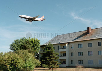 Flugzeug im Landeanflug ueber Wohnhaeusern in Tegel
