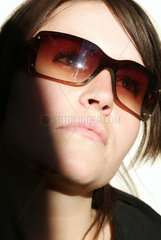 Berlin  junge Frau mit Sonnenbrille schaut nach oben
