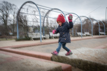 Berlin  Deutschland  kleines Maedchen spielt auf einem Spielplatz
