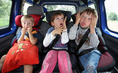 Werl  Deutschland  Kinder in einem Auto schneiden Grimassen