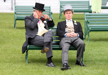 Ascot  Grossbritannien  elegant gekleidete Maenner sitzen auf einer Bank