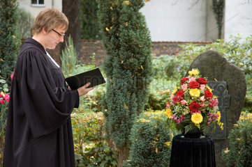 Berlin  Deutschland  Pastor auf einem Friedhof vor einem Familiengrab