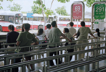 Fahrgaeste warten am Busbahnhof Tampines in Singapur