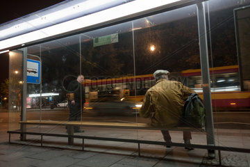 Warschau  Polen  Maenner warten an der Bushaltestelle