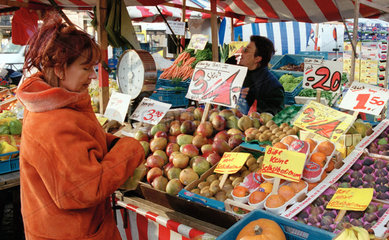 Frau beim Einkauf an einem Obststand am Wochenmarkt