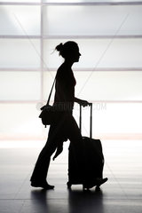 Berlin  Deutschland  Silhouette einer jungen Frau mit Koffer