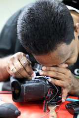 Dubai  Vereinigte Arabische Emirate  Mitarbeiter des Canon Professional Service reinigt eine Spiegelreflexkamera