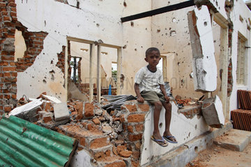 Vakarai  Sri Lanka  Kind sitzt auf Mauerresten