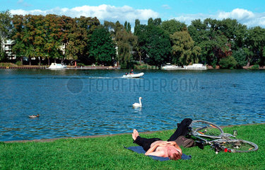 Berlin  Ein Mann sonnt sich im Treptower Park