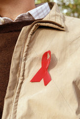 Rote AIDS-Schleife an einer Jacke als Solidaritaetssymbol