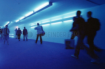 Besucher auf der IFA in einem blau beleuchteten Gang