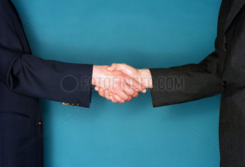 Handschlag zwischen zwei Maennern im Anzug