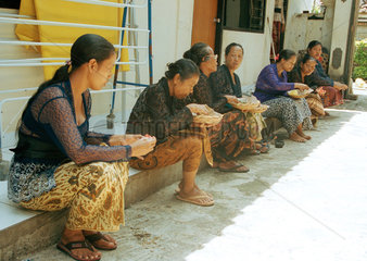 Eine Gruppe von trauernden Frauen sitzt im Hof eines Verstorbenen