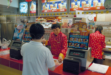 Mitarbeiterin und Kundin in einer McDonald's Filiale in Singapur