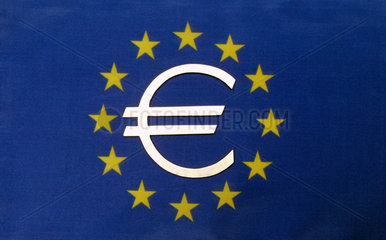 Das Eurozeichen auf einer EU-Flagge liegend