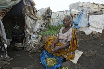 Goma  Demokratische Republik Kongo  Frau putzt vor ihrer Huette Gemuese