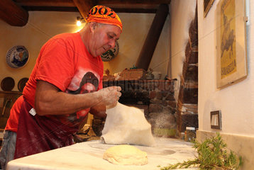 Torre Alfina  Italien  Pizzabaecker bestaeubt einen Pizzateig mit Mehl