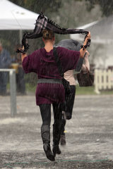 Hannover  Deutschland  Frau versucht sich mit einem Tuch vor einem Regenschauer zu schuetzen