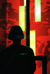 Silhouette einer Frau vor farbig beleuchteter Wand