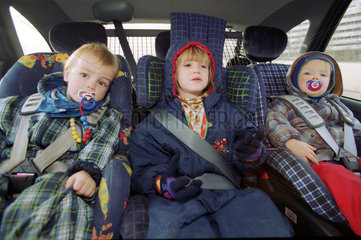 Drei Kinder angeschnallt in ihren Kindersitzen